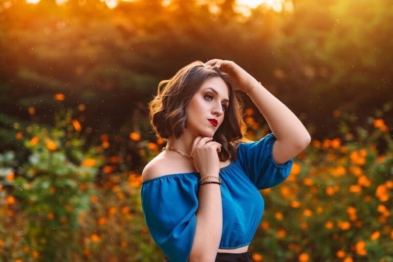 Charming portrait of a woman in a garden during sunset, exuding grace and fashion in vibrant lighting.