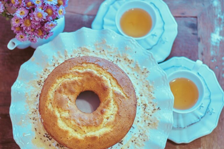 baked bundt cake on cake stand. Imagem ilustrativa para Bolo Cremoso de Fubá de Liquidificador.
