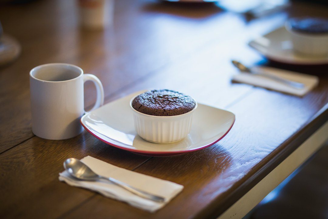 cupcake in ramekin beside mug. Imagem ilustrativa para Brownie de Caneca Microondas: A Sobremesa Rápida e Deliciosa que Você Precisa Conhecer.