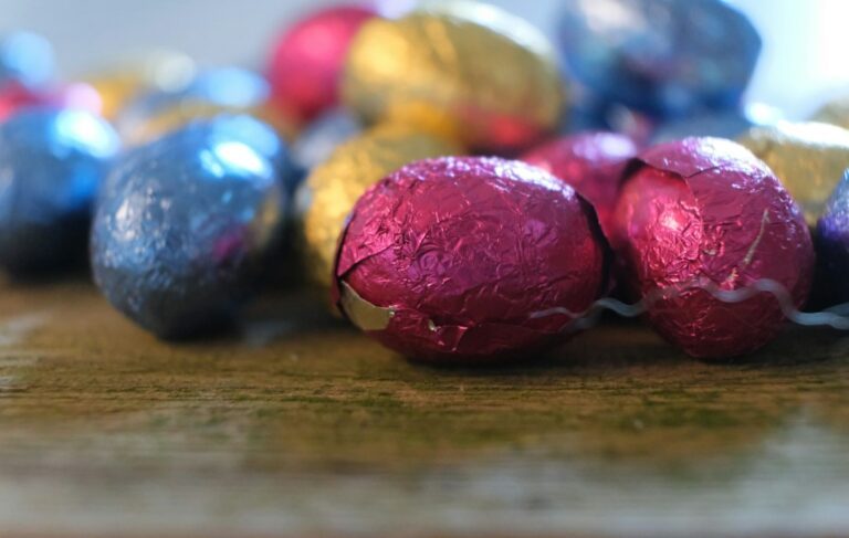 a bunch of chocolate eggs sitting on top of a wooden table. Imagem ilustrativa para Guia Completo para Fazer Ovos de Páscoa Incríveis: Dicas e Receitas.