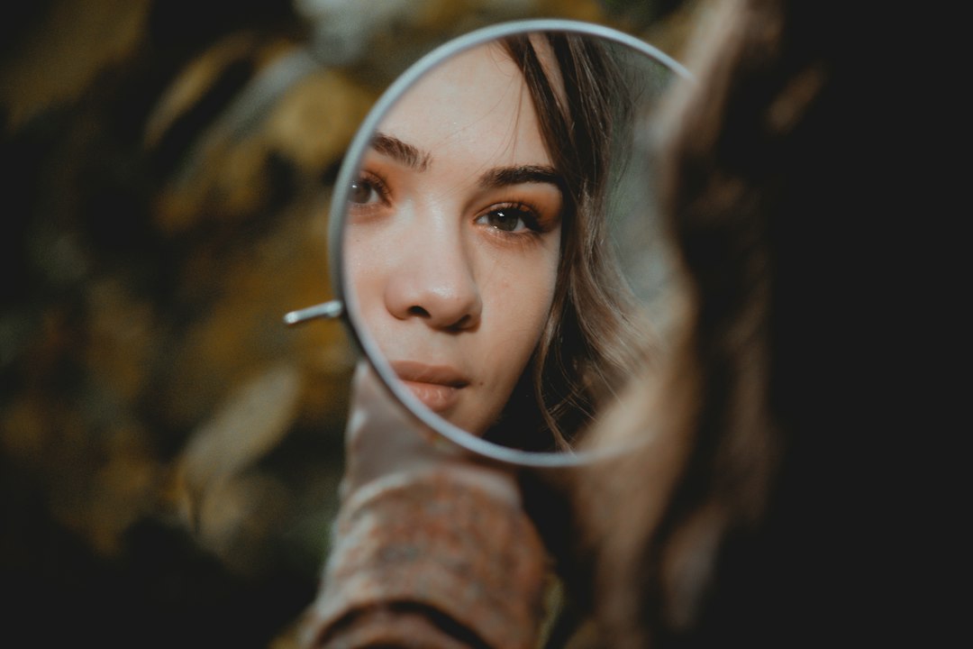Mulher observando seu reflexo em um espelho