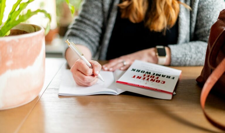Mulher anotando planos em caderno