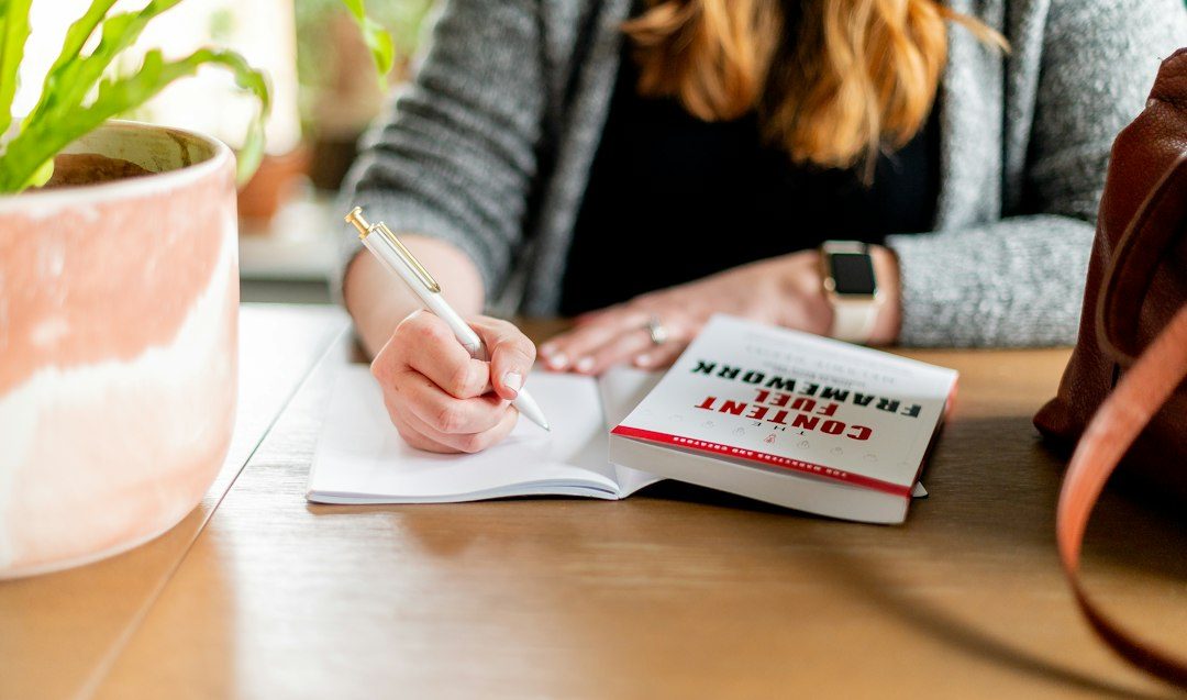 Mulher anotando planos em caderno