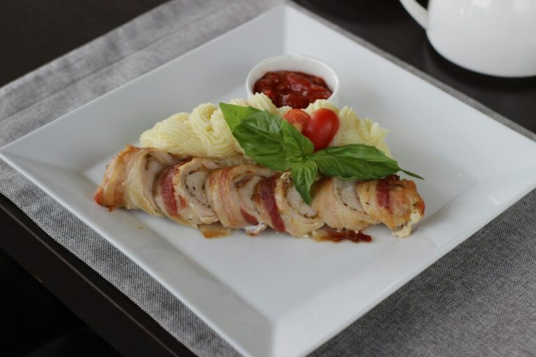 Bacon-wrapped meatloaf with mashed potatoes and sauce. Imagem ilustrativa para Lombo de Porco Recheado com Queijo e Bacon.