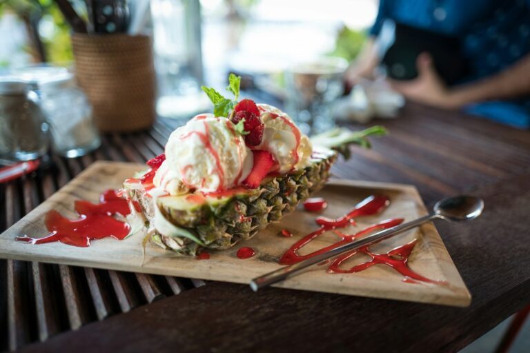 Ice cream with fruit served in a pineapple boat. Imagem ilustrativa para Sobremesa Fácil de Abacaxi com Apenas 3 Ingredientes.