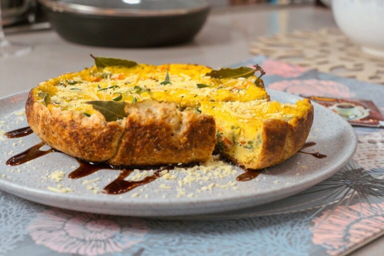 a quiche with a piece cut out of it on a plate. Imagem ilustrativa para Torta de Pão Fácil e Deliciosa: Receita Rápida para Surpreender!.